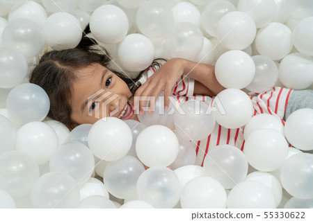 asian child girl play with white plastic balls asian child girl play with white plastic balls 55330622