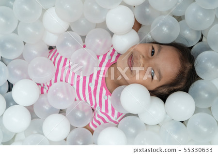 asian child girl play with white plastic balls asian child girl play with white plastic balls 55330633