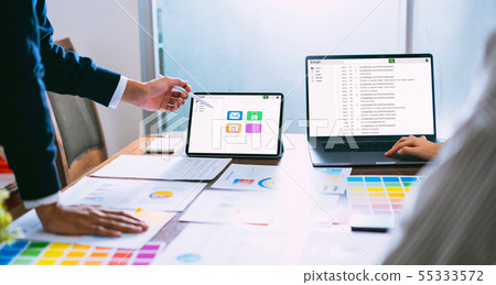 Businessman using laptop and tablet reading email 55333572