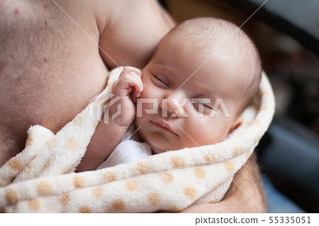 Young father holding his sweet adorable sleeping newborn child 55335051