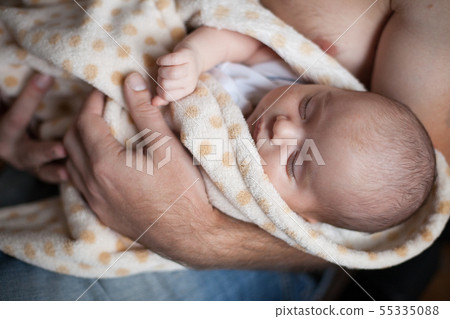 Young father holding his sweet adorable sleeping newborn child 55335088