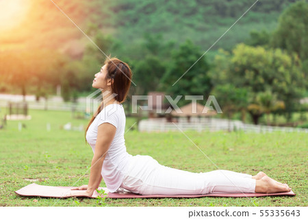 woman sitting on yoga mat practice Cobra Pose woman sitting on yoga mat practice Cobra Pose 55335643