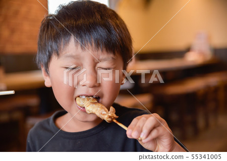 Child eating Yakitori 55341005
