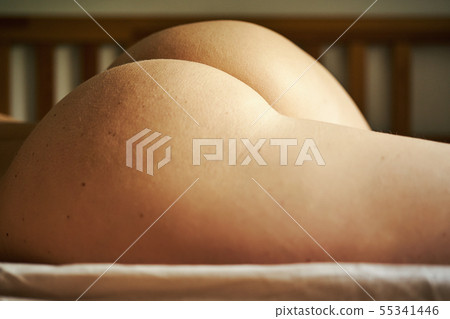 Closeup on beautiful buttocks of young naked woman on bed Closeup on beautiful buttocks of young naked woman on bed 55341446