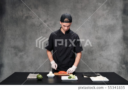 Chef man in the kitchen at the restaurant. Ingredients for sushi and rolls. Chef man in the kitchen at the restaurant. Ingredients for sushi and rolls. 55341835