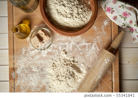Ingredients for dough on pastry board with flour and rolling pin on table 55341841