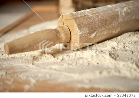 Rolling pin on pastry board sprinkled with flour on wooden  table 55342372