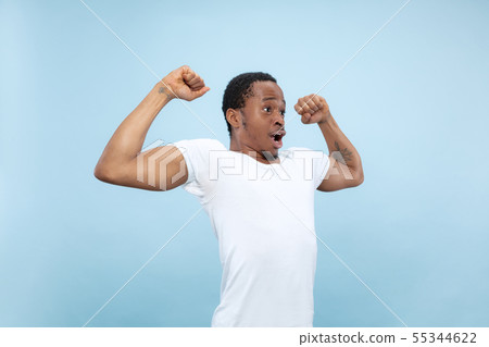 Half-length close up portrait of young man on blue background. Half-length close up portrait of young man on blue background. 55344622