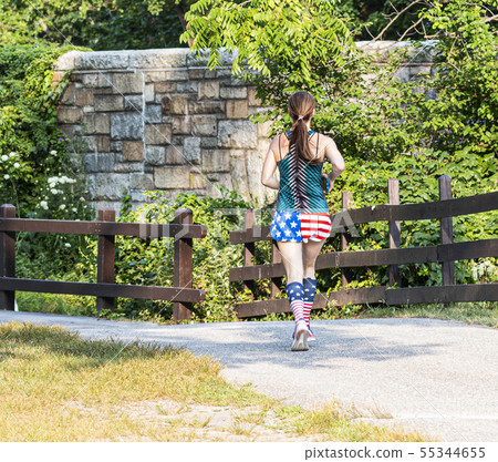 Rear view of female runner in patriotic shorts and 55344655