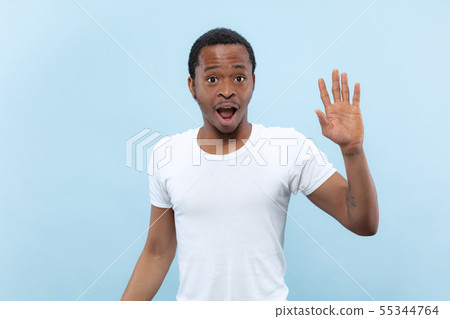 Half-length close up portrait of young man on blue background. Half-length close up portrait of young man on blue background. 55344764