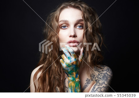 Young Woman with Tattoo and color paint on her Young Woman with Tattoo and color paint on her 55345039