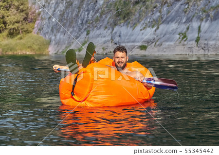 Young man is swimming on air sofa. 55345442