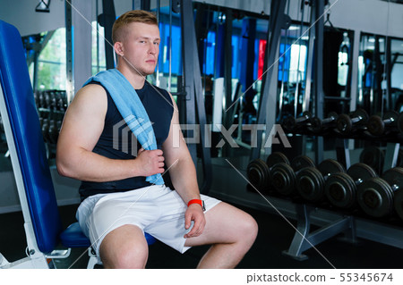 athlete rests between sets in weight training 55345674