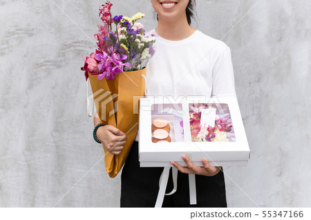 Portrait of cheerful woman holding flowers and gift box. Portrait of cheerful woman holding flowers and gift box. 55347166