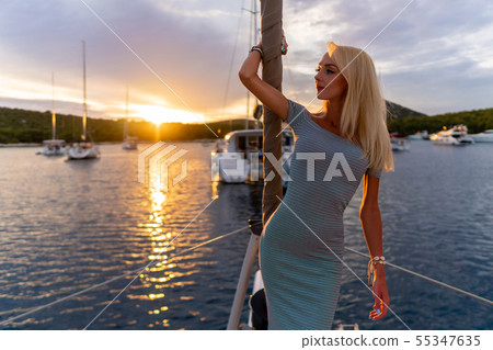 beautiful sexy woman in dress relaxing on a yacht front at sunset beautiful sexy woman in dress relaxing on a yacht front at sunset 55347635