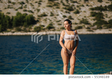 Sexy woman in bikini stand in front of beautiful blue water. Summer vocation on the sea 55348189