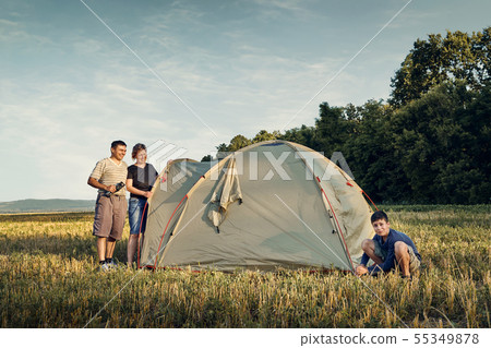 Family set up tent camp at sunset, beautiful 55349878