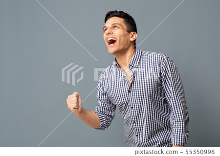 Happy Arab Guy Shaking Clenched Fist On Gray Background 55350998