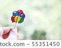 Hand holding paper balloons 55351450