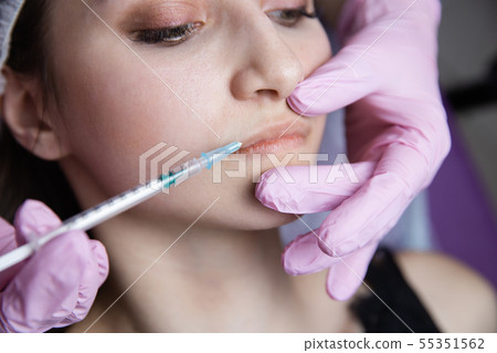 The doctor cosmetologist makes the Rejuvenating facial injections procedure for tightening and 55351562