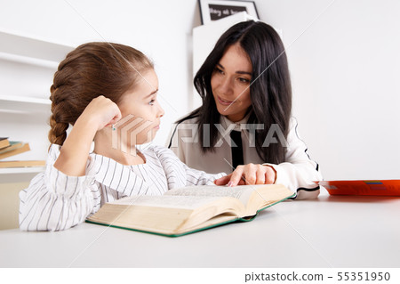 Mother sitting with baby girl and teaching her to read. Mother sitting with baby girl and teaching her to read. 55351950