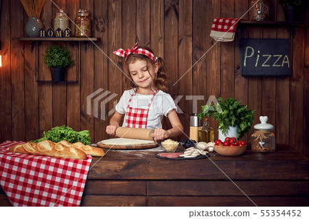 Pretty girl in checkered apron rolling out dough for pizza 55354452