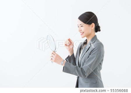 Woman looking at a mirror (business) Woman looking at a mirror (business) 55356088