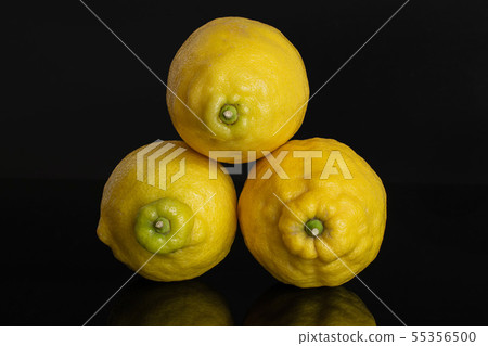 Fresh yellow lemon isolated on black glass Fresh yellow lemon isolated on black glass 55356500