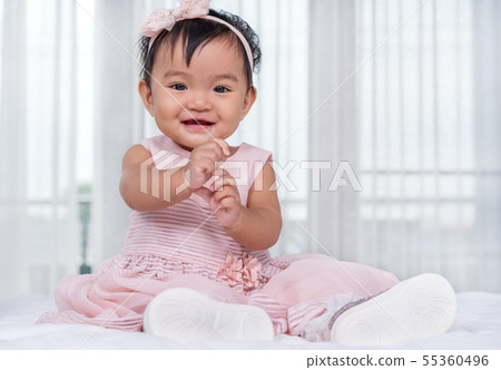 baby in pink dress on bed baby in pink dress on bed 55360496