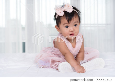 baby in pink dress on bed baby in pink dress on bed 55360508