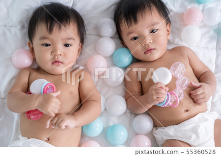 cheerful twin babies on bed 55360528