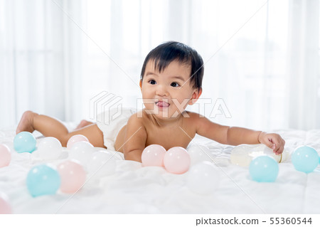 cheerful baby lying on bed 55360544