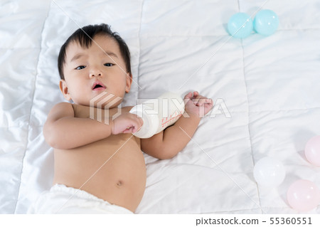 cheerful baby lying on bed cheerful baby lying on bed 55360551