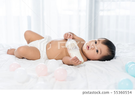 cheerful baby lying on bed 55360554