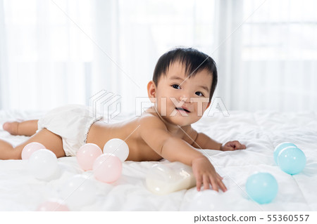cheerful baby lying on bed cheerful baby lying on bed 55360557
