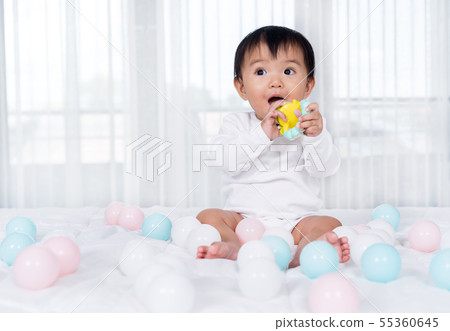 cheerful baby playing color ball on bed cheerful baby playing color ball on bed 55360645