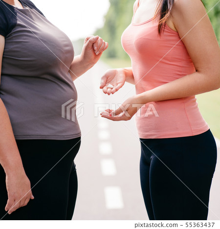 Overweight woman take slimming pills from friend 55363437