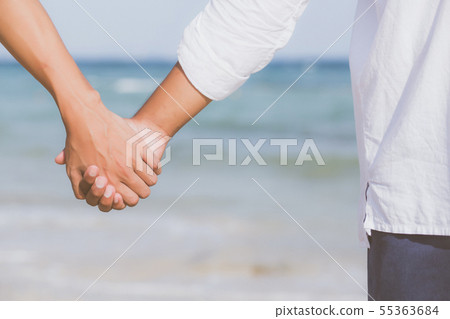 Closeup gay couple holding hands together on beach 55363684