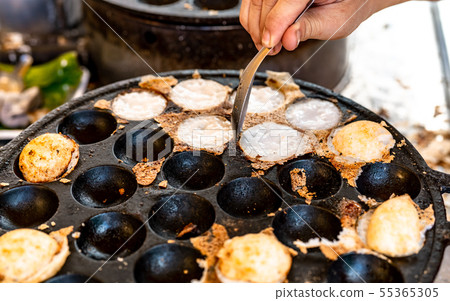 Kanom Krok is Thai traditional dessert. Woman hand 55365305