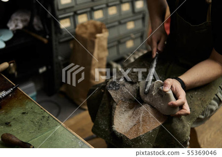 Shoemaker shaving a shoe mold at work place Shoemaker shaving a shoe mold at work place 55369046