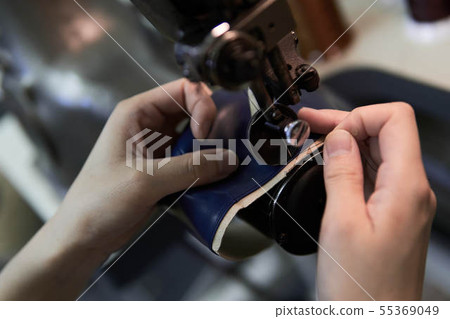 Female hand sewing leather with a sewing machine 55369049