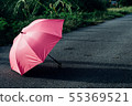 Pink umbrella on concrete floor and green grass fi 55369521