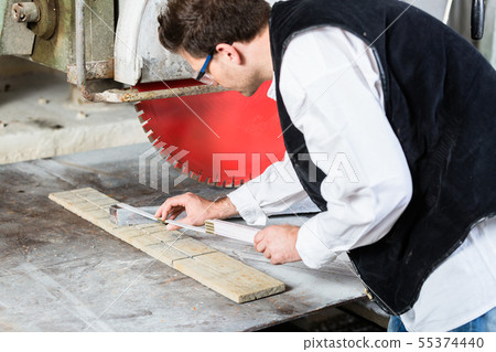 Handyman in stone carving factory at diamond saw 55374440
