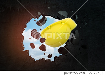 3d rendering of yellow hard hat breaking hole in black wall with blue sky seen through hole. 3d rendering of yellow hard hat breaking hole in black wall with blue sky seen through hole. 55375719