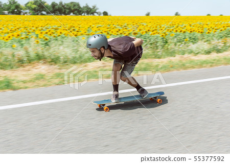 Skateboarder doing a trick at the city's street in sunny day 55377592