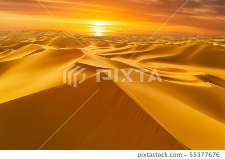 Sunset over the sand dunes in the desert Sunset over the sand dunes in the desert 55377676