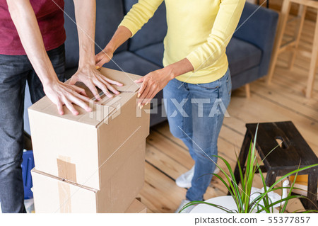 Close up of hand packing cardboard box, concept moving house. Young couple moving to a new apartment 55377857
