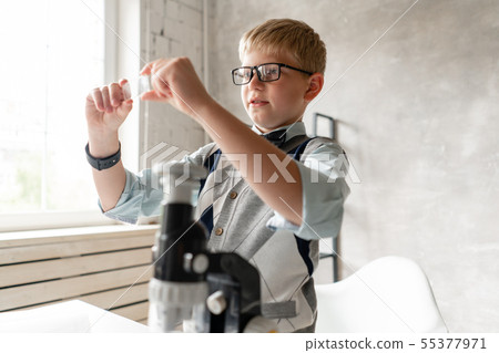 Young boy preparing samples for examination under microscope Young boy preparing samples for examination under microscope 55377971