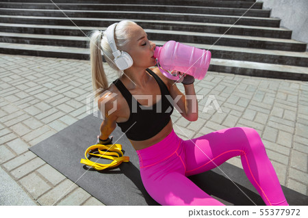 A young athletic woman working out at the city's street A young athletic woman working out at the city's street 55377972