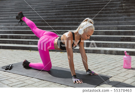 A young athletic woman working out at the city's street A young athletic woman working out at the city's street 55378463